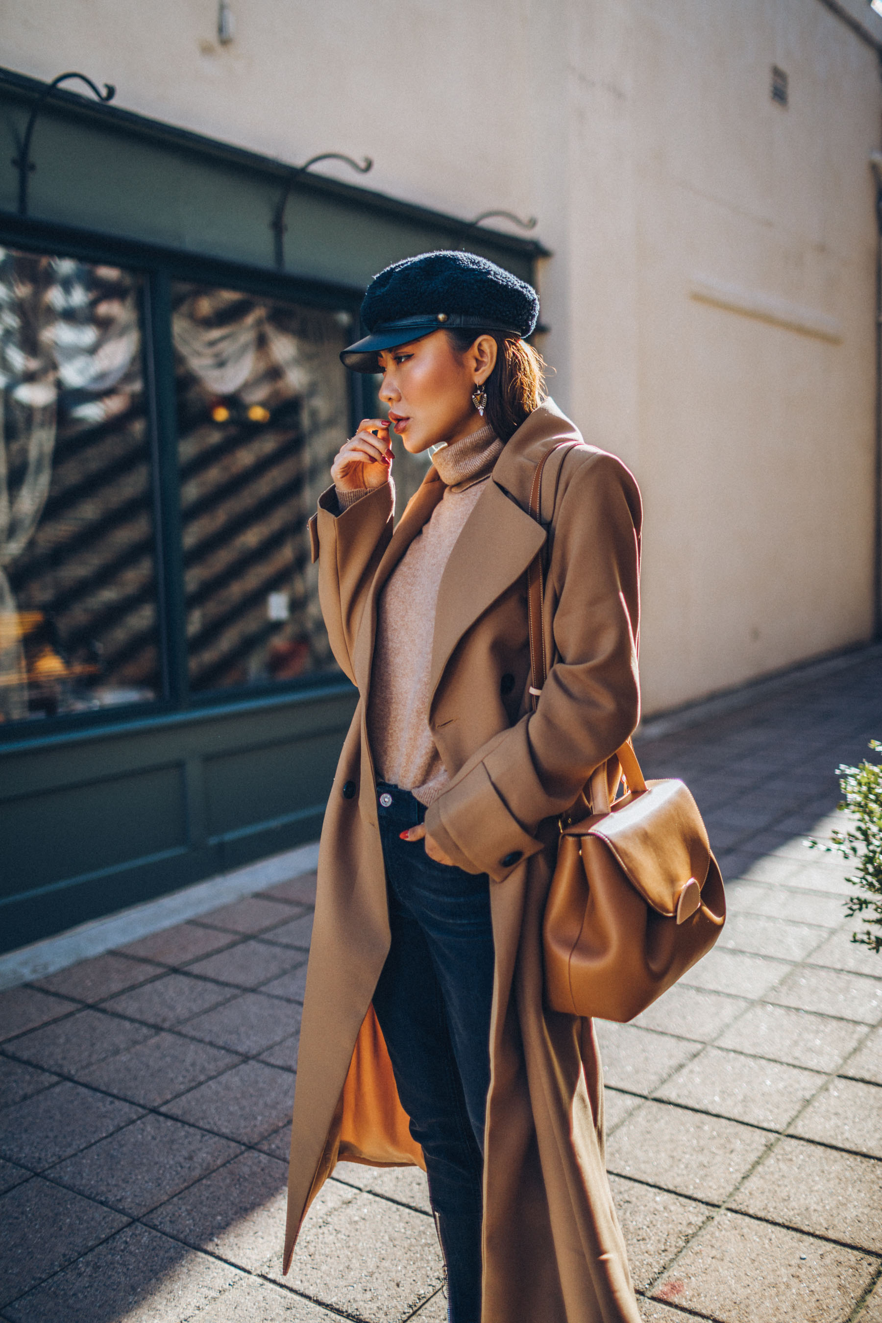 How to Buy an Investment Coat - Belted Camel Coat with Dark Denim Baker Boy Cap and Satchel // Notjessfashion.com // New York fashion blogger, asian blogger, classic camel coat, winter outfit, classic winter outfit, cozy layered outfut, nude boots, nude bag, baker boy hat, how to style camel coat, jessica wang, fashion blogger, street style, fashion blogger street style, oversized coat, duster coat, maxi coat