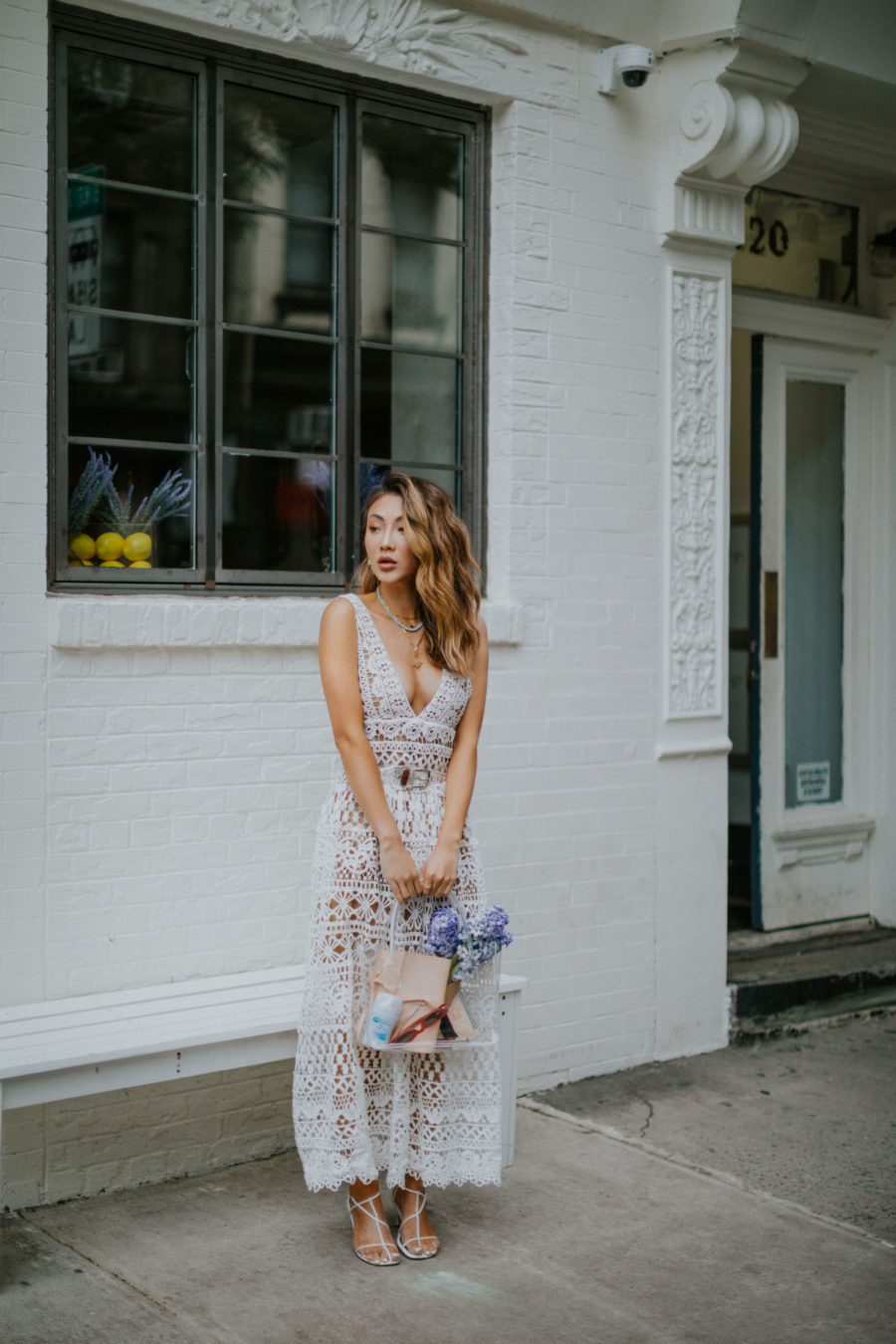 jessica wang wearing a lace white dress with a clear handbag while sharing her favorite wedding guest dresses from amazon // Jessica Wang - Notjessfashion.com