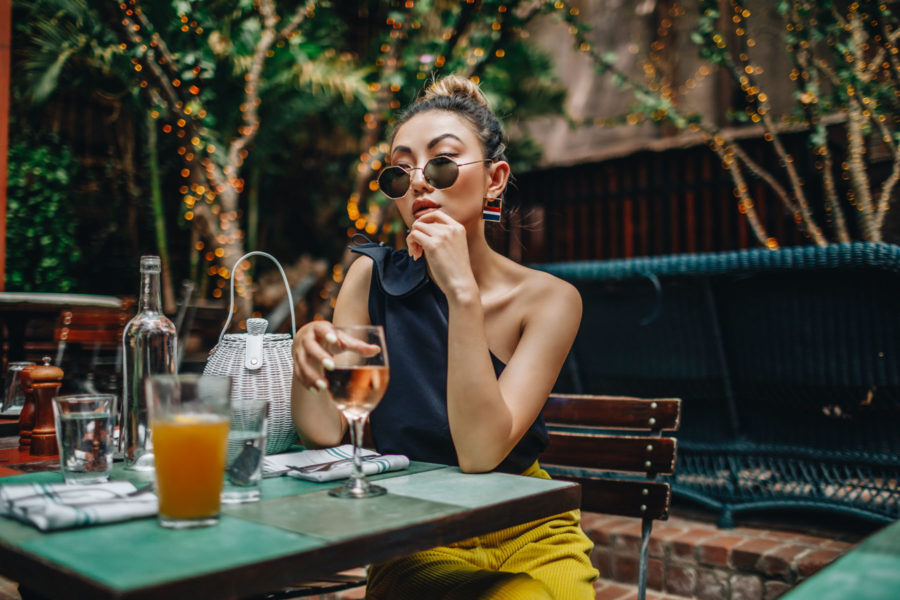 safe outdoor activities to do in nyc - jessica wang dining outdoors, wearing a black one shoulder tank top, woven basket hand bag // Jessica Wang - Notjessfashion.com