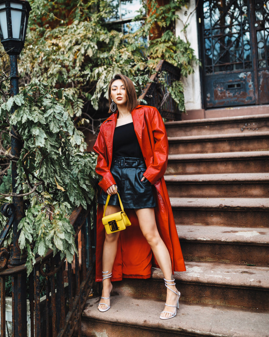 fashion blogger jessica wang shares ugly fashion trends of 2020 wearing red trench coat with leather shorts and rene caovilla heels // Notjessfashion.com