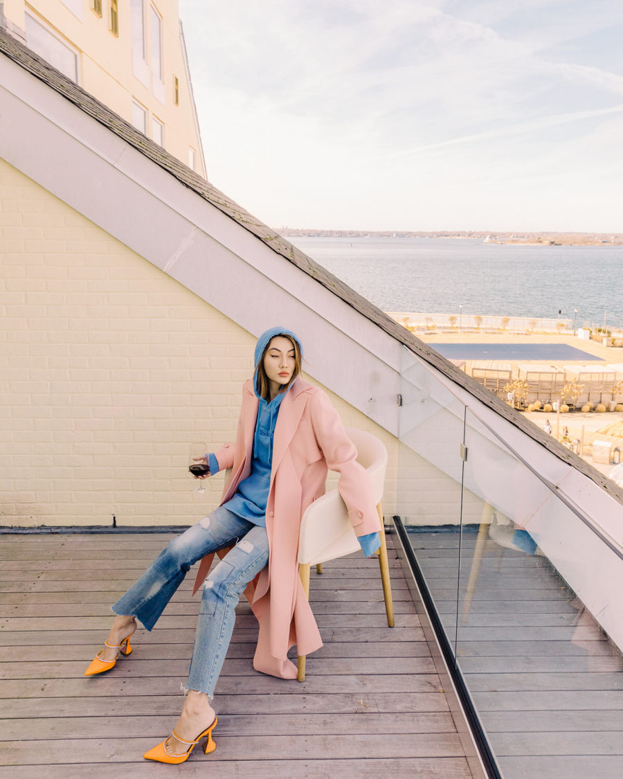 fashion blogger jessica wang shares ways to look more sophisticated on a budget wearing a pink trench coat blue hoodie and amina muaddi heels // Notjessfashion.com