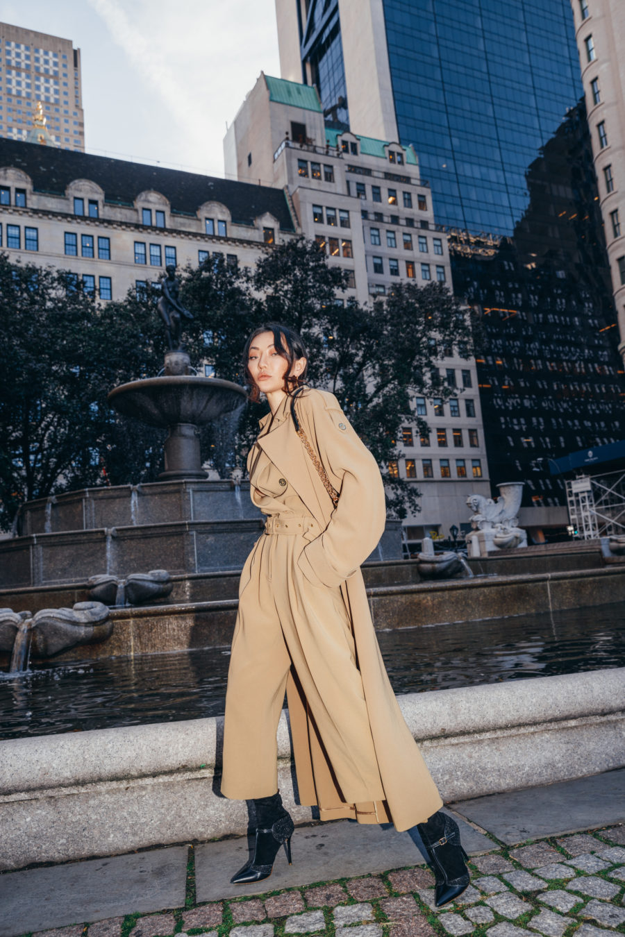 Jessica Wang wearing a summer to fall outfit featuring a trench coat, a camel top and pants with black boots // Jessica Wang - Notjessfashion.com