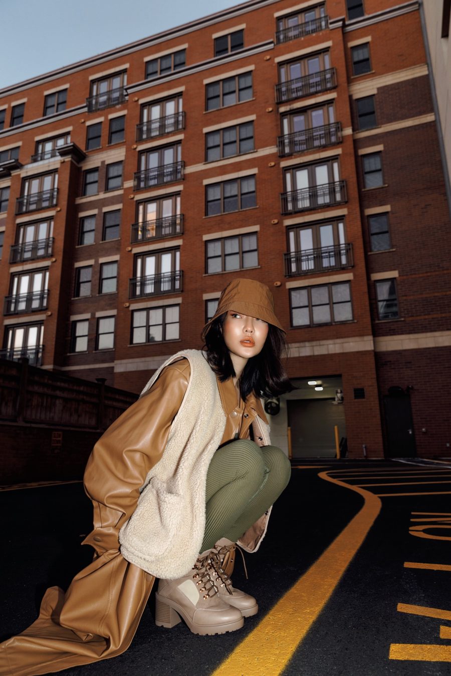 Jessica Wang wearing a faux fur vest, leather shacket and tights with a bucket hat while sharing tips on how to layer for winter // Jessica Wang - Notjessfashion.com