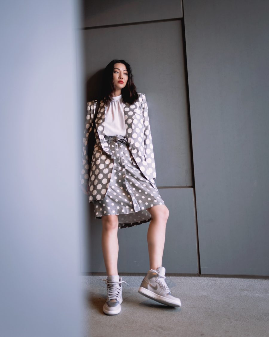 jessica wang wearing a polka dot blazer and polka dot midi skirt with gray sneakers while sharing casual spring suits for women // Jessica Wang - Notjessfashion.com